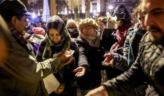 Las filas del hambre que se forman todos los días de la semana en la Plaza de Mayo muestran una de las postales más dolorosas de la Argentina actual. Miles de personas, entre ellas familias enteras, jubilados y niños, esperan durante horas por un plato de comida caliente porque en sus hogares ya no hay nada para poner sobre la mesa. Chicos comiendo en la vereda y en mesas improvisadas reflejan una crisis social que ya golpea a los sectores más vulnerables.